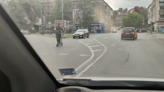 Баща и дете на една тротинетка по средата на пътя